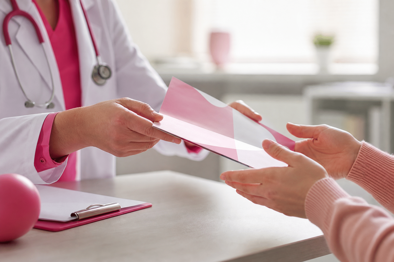 Ein Arzt überreicht einer Patientin im Erstgespräch ein schriftliches Aufklärungsdokument über einen plastisch-chirurgischen Eingriff.